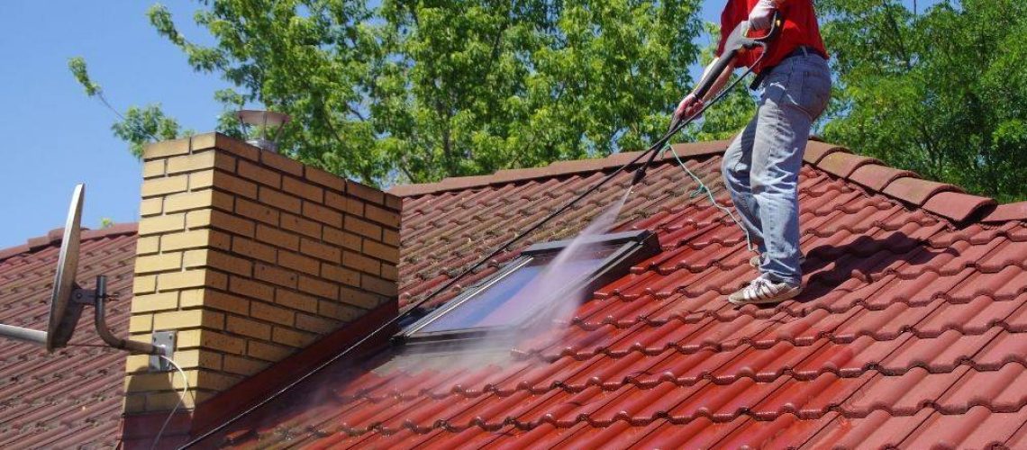 man power washing red tiled roof